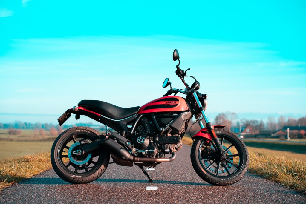 Red and black motor bike positioned perpendicular to the road